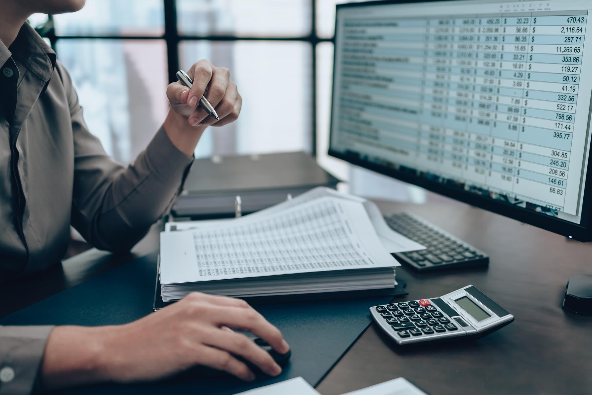 Investors working on desk office and check data cost, balance, profit and currency on monitor screen. Accounting and Financial concept.